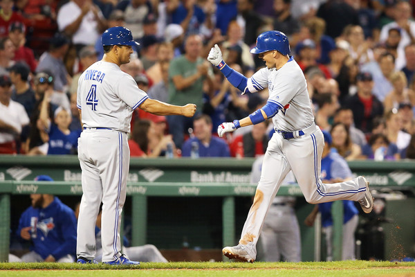 Ryan Goins celebrates with third base coach Luis Rivera after hitting a solo home run in the ninth to give Toronto some insurance against the Red Sox. | Photo: Adam Glanzman/Getty Images