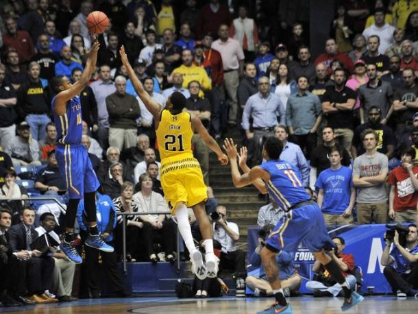 Michigan guard Zak Irvin (21) defends a 3-point attempt by Tulsa guard James Woodard (10) in the last minute of the game.  (Robin Buckson, Detroit News)