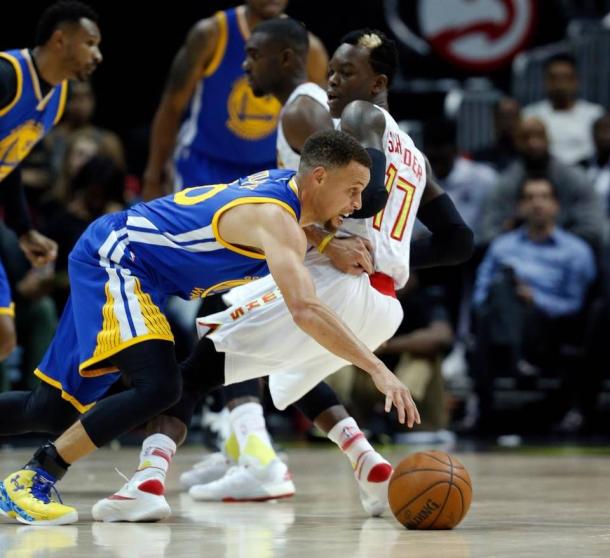 Dennis Schroder goes head to head with Steph Curry. John Bazemore/The Associated Press