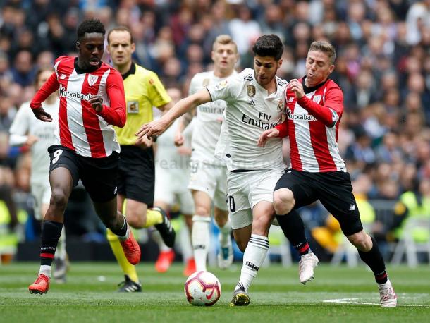 Asensio en una carrera trata de ser frenado / Foto: Real Madrid