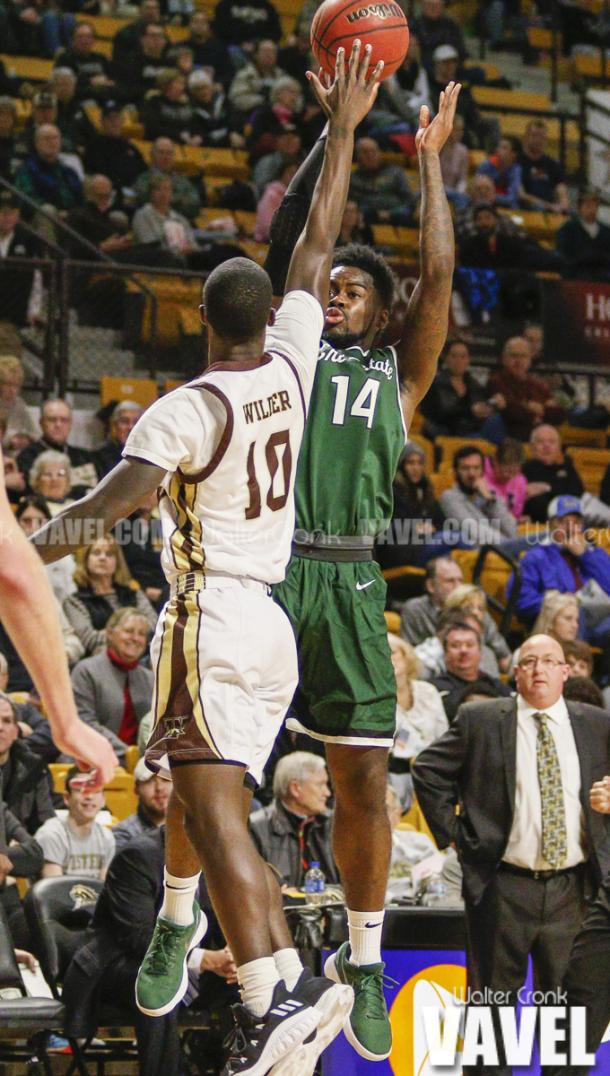 Fred Sims Jr. (14) takes the jump shot over Thomas Wilder (10). Photo: Walter Cronk