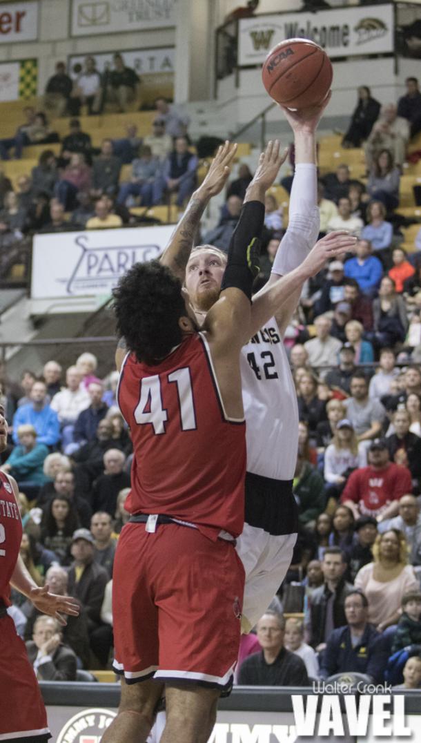 Drake LaMont (42) takes the hook shot over Trey Moses (41). Photo: Walter Cronk