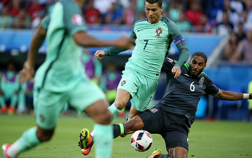 Williams (far left) performing a clean slide tackle to dispossess Real Madrid forward Cristiano Ronaldo during Wales' semi-final defeat against Portugal in the Euros. | Photo: Getty