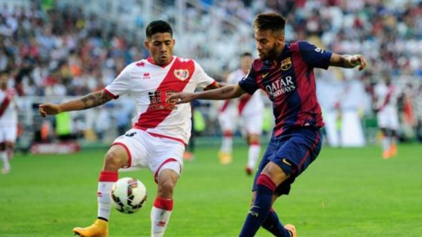 En la imagen, Aquino y Neymar disputándose la pelota en el campo.