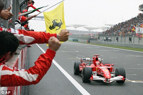 Schumacher, pasando la bandera de cuadros. Foto via: dailymail.co.uk