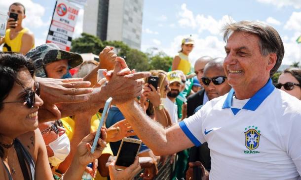 Bolsonaro descumprindo medida cautelar de evitar aglomerações (Foto: Sergio Lima / AFP / EBC)
