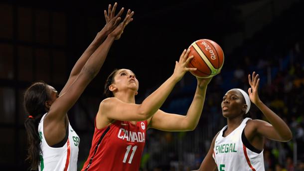 Canada's Natalie Ochonwa goes up for a shot in between two Senegal defenders during their preliminary game in Rio/Photo: 