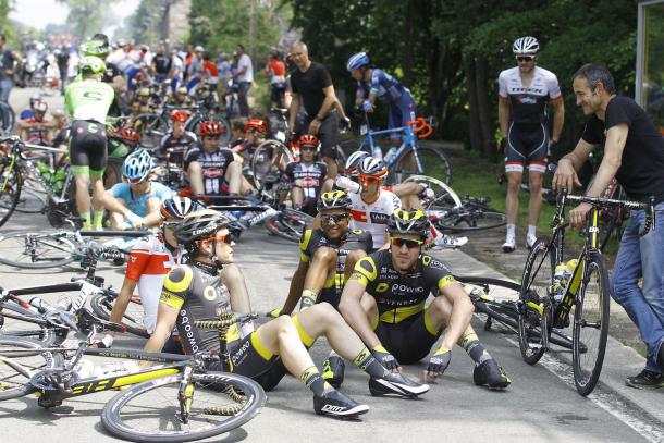 Los ciclistas esperan a pie de asfalto tras la grave caída | Fuente: Giant-Alpecin oficial.