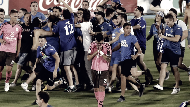 Aficionados del Getafe invaden el campo ante la desolación de dos jugadores del Tenerife. Fuente: Efe