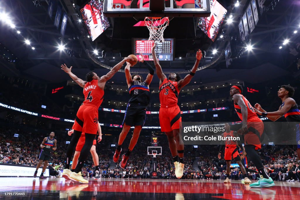 Cade Cunningham #2 of the Detroit Pistons (C) drives to the basket between Scottie Barnes #4 and O.G. Anunoby #3 of the Toronto Raptors during the first half of the game at Scotiabank Arena on November 19, 2023 in Toronto, Canada. NOTE TO USER: User expressly acknowledges and agrees that, by downloading and or using this photograph, User is consenting to the terms and conditions of the Getty Images License Agreement. (Photo by Cole Burston/Getty Images)