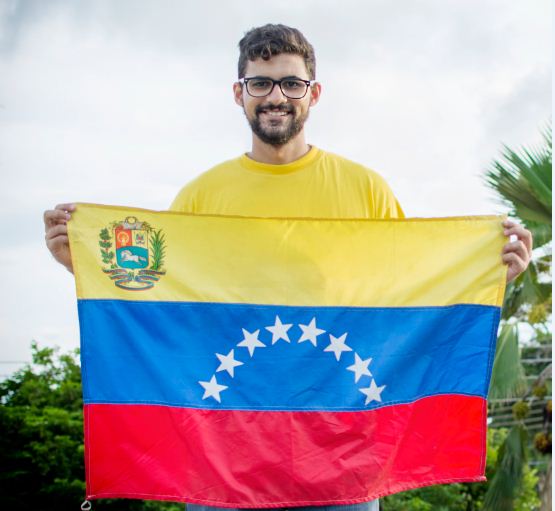 Fabio posa con su camiseta amarilla y su bandera venezolana