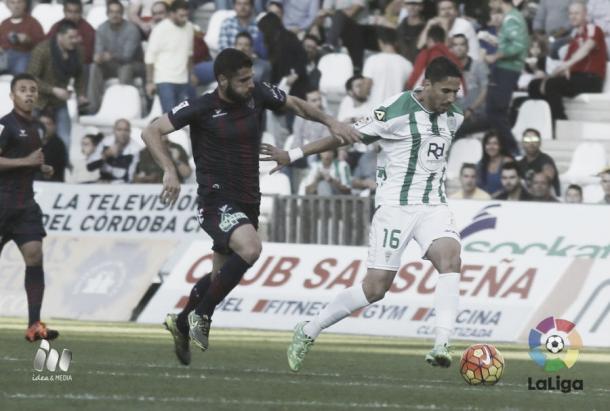 Fidel defiende el balón ante un jugador oscense  Fuente La Liga