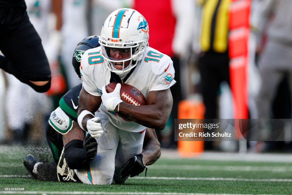 Wide receiver Tyreek Hill #10 of the Miami Dolphins is tackled by cornerback D.J. Reed #4 of the New York Jets after making a catch for a first down during a football game at MetLife Stadium on November 24, 2023 in East Rutherford, New Jersey. (Photo by Rich Schultz/Getty Images)