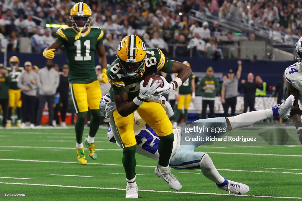 Romeo Doubs #87 of the Green Bay Packers is brought down by Malik Hooker #28 of the Dallas Cowboys during the first half of the NFC Wild Card Playoff game at AT&T Stadium on January 14, 2024 in Arlington, Texas. (Photo by Richard Rodriguez/Getty Images)