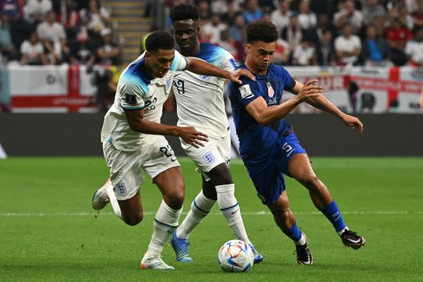 Antonee Robinson disputa un balón con Bellingham y Saka / Fuente: Getty Images