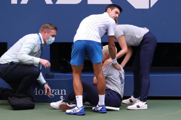 Djokovic looks on as officials attend to the line judge that was struck by a ball from the Serb/Photo: Al Bello/Getty Images