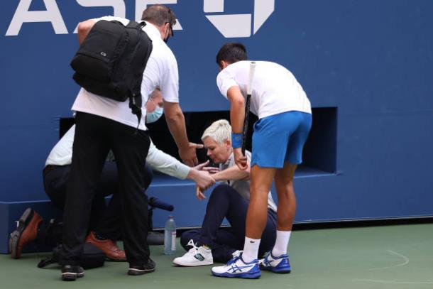 US Open medical personnel tend to the line judge who was struck by a ball hit by Djokovic, who looks on in concern/Photo: Al Bello/Getty Images