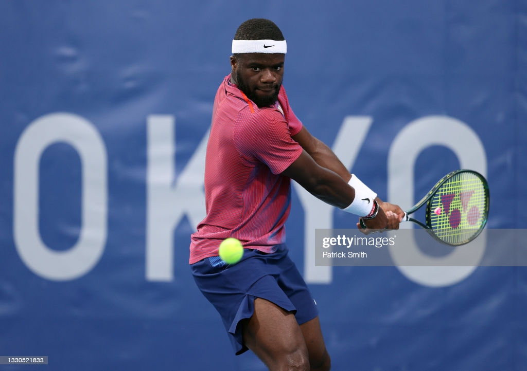 Tiafoe hits a backhand during his opening match at the Olympics/Patrick Smith/Getty Images