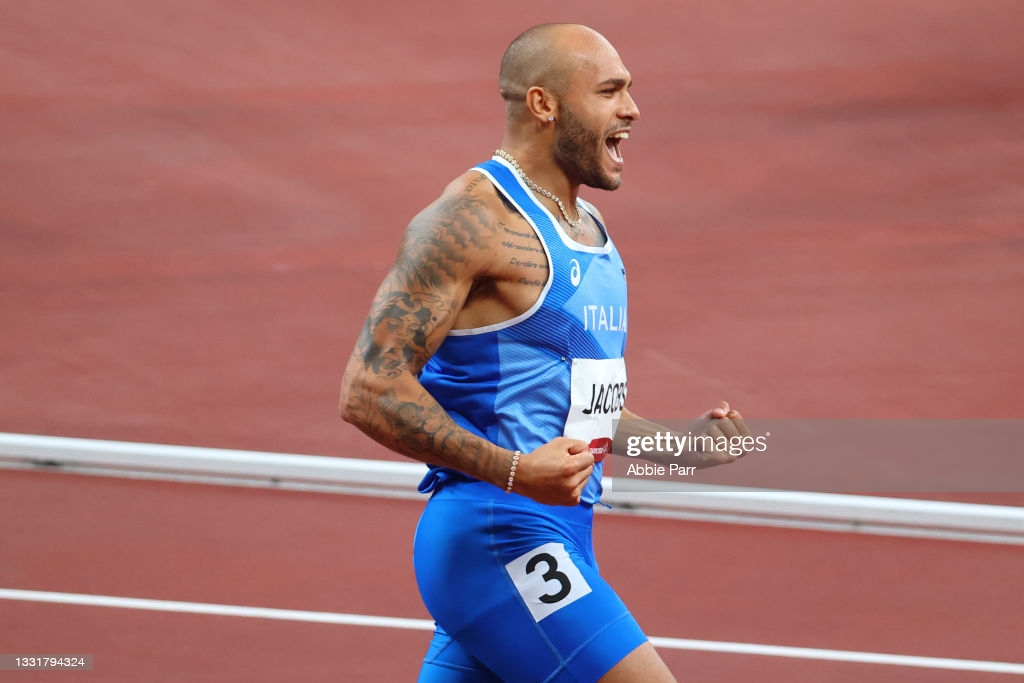 Marcell Jacobs celebrates after crossing the finish line first in the 100 meters at the Olympics/Photo: Abbie Parr/Getty Images