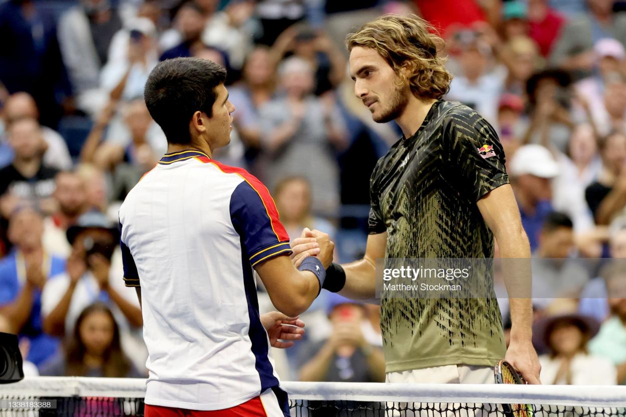 Tsitsipas and Alcaraz share a moment at the net after their match (Matthew Stockman/Getty Images)