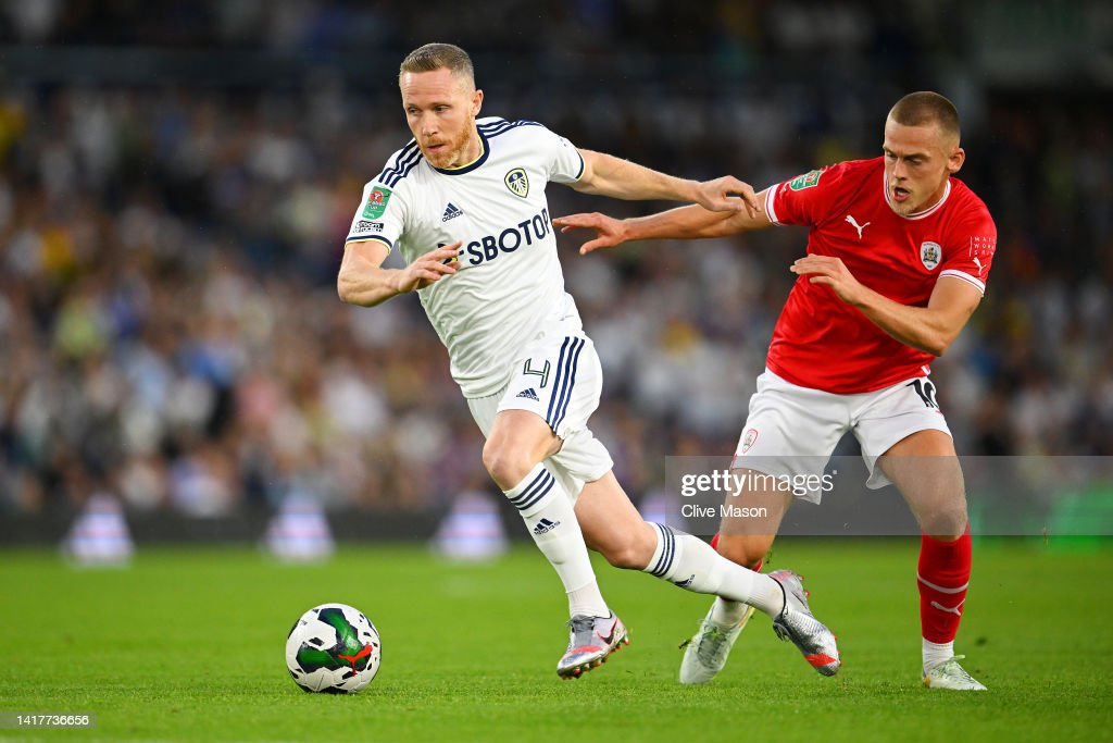 LEEDS, ENGLAND - AUGUST 24: Adam Forshaw of Leeds United is challenged by Josh Benson of Barnsley during the Carabao Cup Second Round match between Leeds United and Barnsley at Elland Road on August 24, 2022 in Leeds, England. (Photo by Clive Mason/Getty Images)