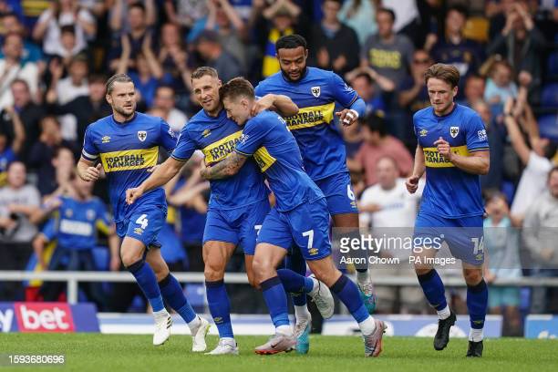 AFC Wimbledon players surround James Tilley's goal from the penalty spot leveled the match/Photo: Aaron Chown/PA Images via Getty Images