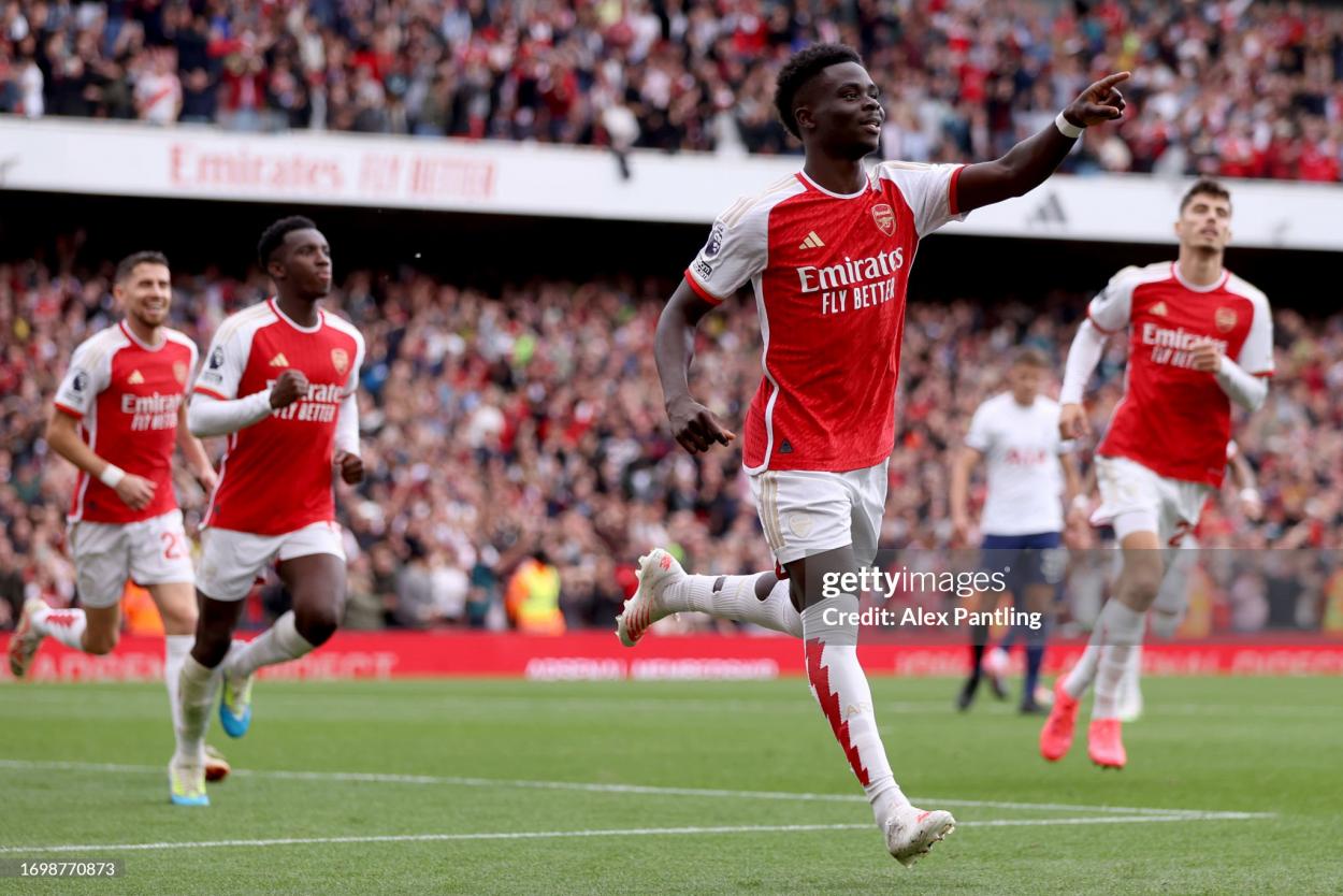 LONDON, ENGLAND - SEPTEMBER 24: <strong><a  data-cke-saved-href='https://www.vavel.com/en/football/2023/08/21/premier-league/1153935-crystal-palace-0-1-arsenal-post-match-player-ratings.html' href='https://www.vavel.com/en/football/2023/08/21/premier-league/1153935-crystal-palace-0-1-arsenal-post-match-player-ratings.html'>Bukayo Saka</a></strong> of Arsenal celebrates after scoring the team's second goal from the penalty spot during the <b><a  data-cke-saved-href='https://www.vavel.com/en/data/premier-league' href='https://www.vavel.com/en/data/premier-league'>Premier League</a></b> match between Arsenal FC and Tottenham Hotspur at Emirates Stadium on September 24, 2023 in London, England. (Photo by Alex Pantling/Getty Images)