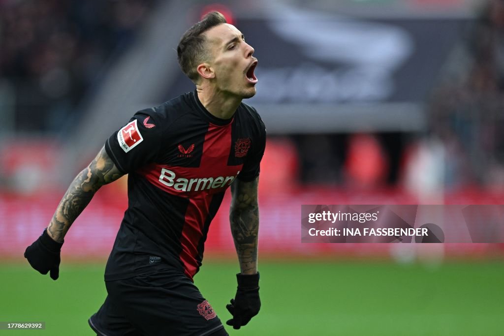 Bayer Leverkusen's Spanish defender #20 <strong><a  data-cke-saved-href='https://www.vavel.com/en/international-football/2023/09/15/germany-bundesliga/1156090-bayern-munich-2-2-bayer-leverkusen-points-shared-after-a-thrilling-night-in-munich.html' href='https://www.vavel.com/en/international-football/2023/09/15/germany-bundesliga/1156090-bayern-munich-2-2-bayer-leverkusen-points-shared-after-a-thrilling-night-in-munich.html'>Alejandro Grimaldo</a></strong> celebrates scoring his team's first goal during the German first division Bundesliga football match Bayer 04 Leverkusen v 1 FC Union Berlin in Leverkusen, western Germany on November 12, 2023. (Photo by INA FASSBENDER / AFP) / DFL REGULATIONS PROHIBIT ANY USE OF PHOTOGRAPHS AS IMAGE SEQUENCES AND/OR QUASI-VIDEO (Photo by INA FASSBENDER/AFP via Getty Images)