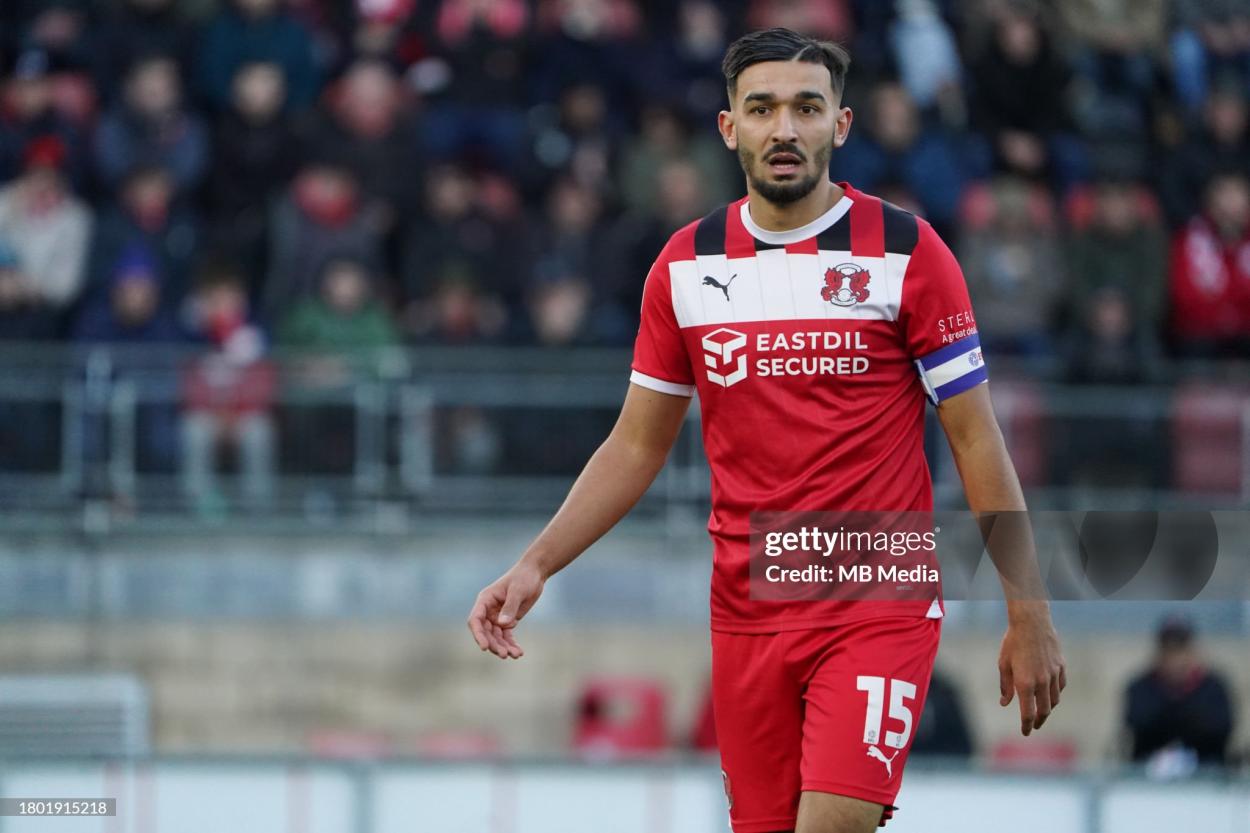 Idris El Mizouni wearing the Captain's armband for <strong><a  data-cke-saved-href='https://www.vavel.com/en/football/2023/09/13/championship/1155862-steve-evans-theman-leading-stevenage-to-new-heights.html' href='https://www.vavel.com/en/football/2023/09/13/championship/1155862-steve-evans-theman-leading-stevenage-to-new-heights.html'>Leyton Orient</a></strong> against Wigan Athletic. (Photo by Dylan Hepworth/MB Media/Getty Images)