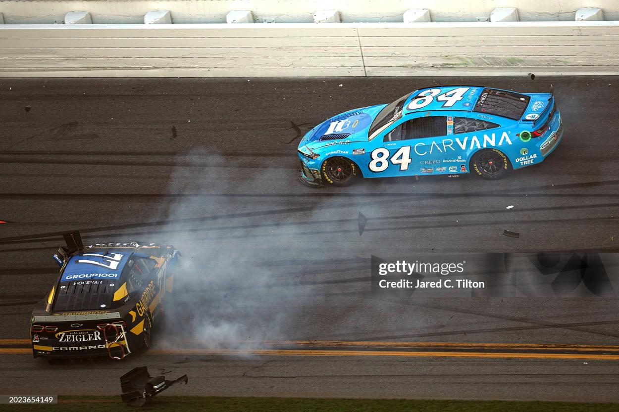 DAYTONA BEACH, FLORIDA - FEBRUARY 19: Carson Hocevar, driver of the #77 Gainbridge/Zeigler Auto Group Chevrolet, spins after an on-track incident ahead of Jimmie Johnson, driver of the #84 Carvana Toyota, during the NASCAR Cup Series Daytona 500 at Daytona International Speedway on February 19, 2024 in Daytona Beach, Florida. (Photo by Jared C. Tilton/Getty Images)