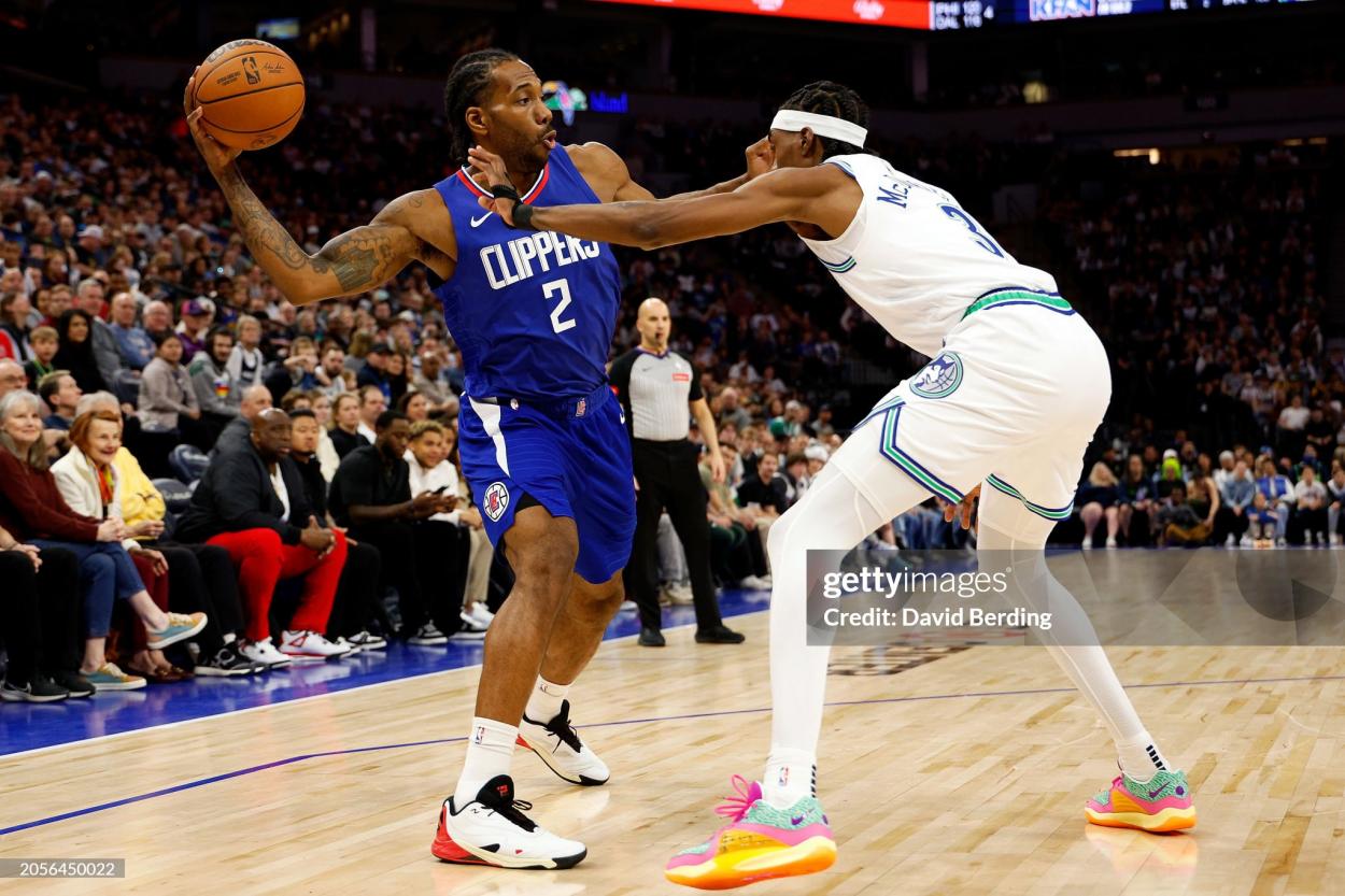 Kawhi Leonard protects the ball from Jaden McDaniels (Photo by David Berding/Getty Images)