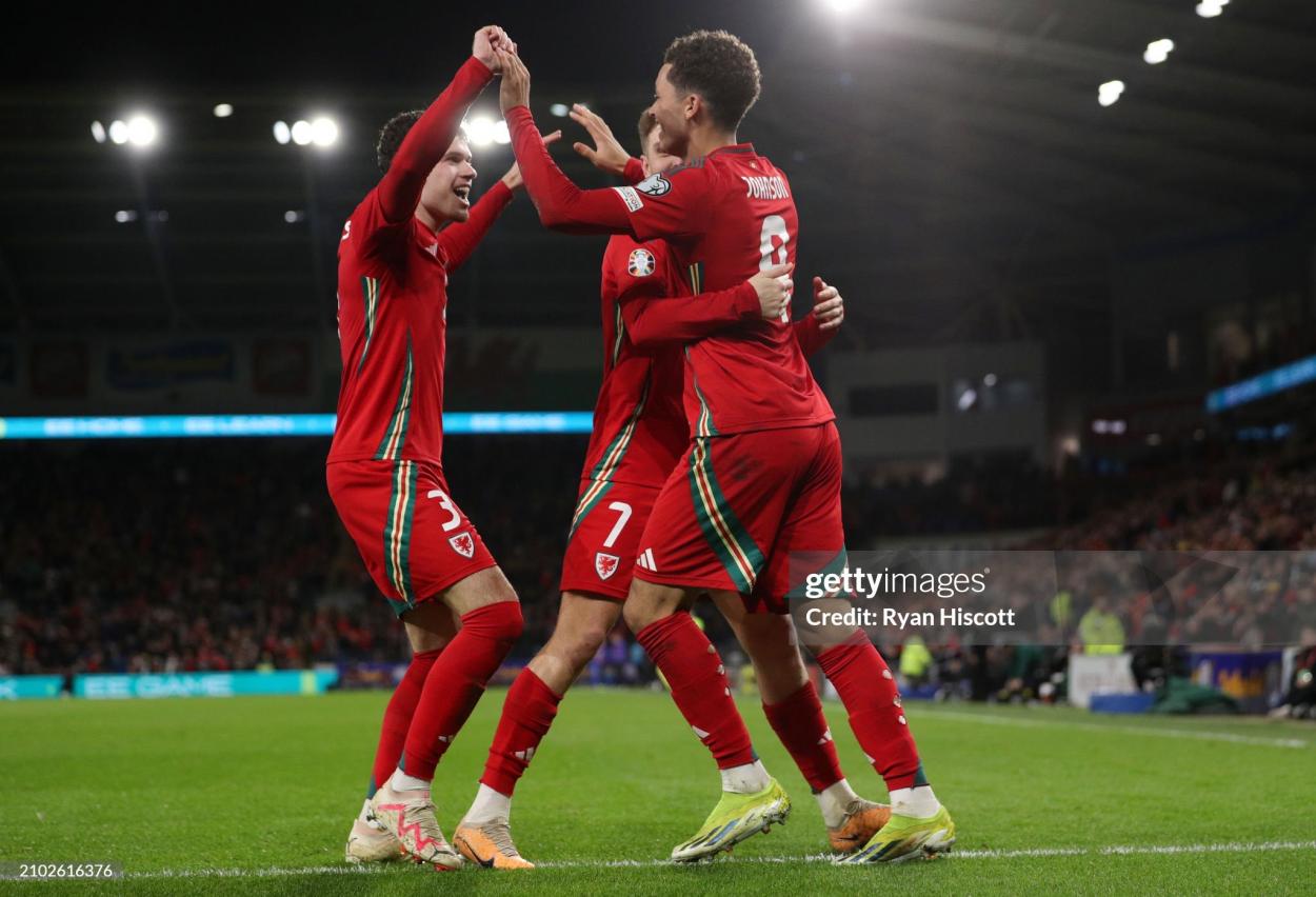 CARDIFF, WALES - MARCH 21: Brennan Johnson of Wales celebrates scoring his team's third goal with Neco Williams and David Brooks during the UEFA EURO 2024 Play-Offs Semi-final match between Wales and Finland at Cardiff City Stadium on March 21, 2024 in Cardiff, Wales. (Photo by Ryan Hiscott/Getty Images)