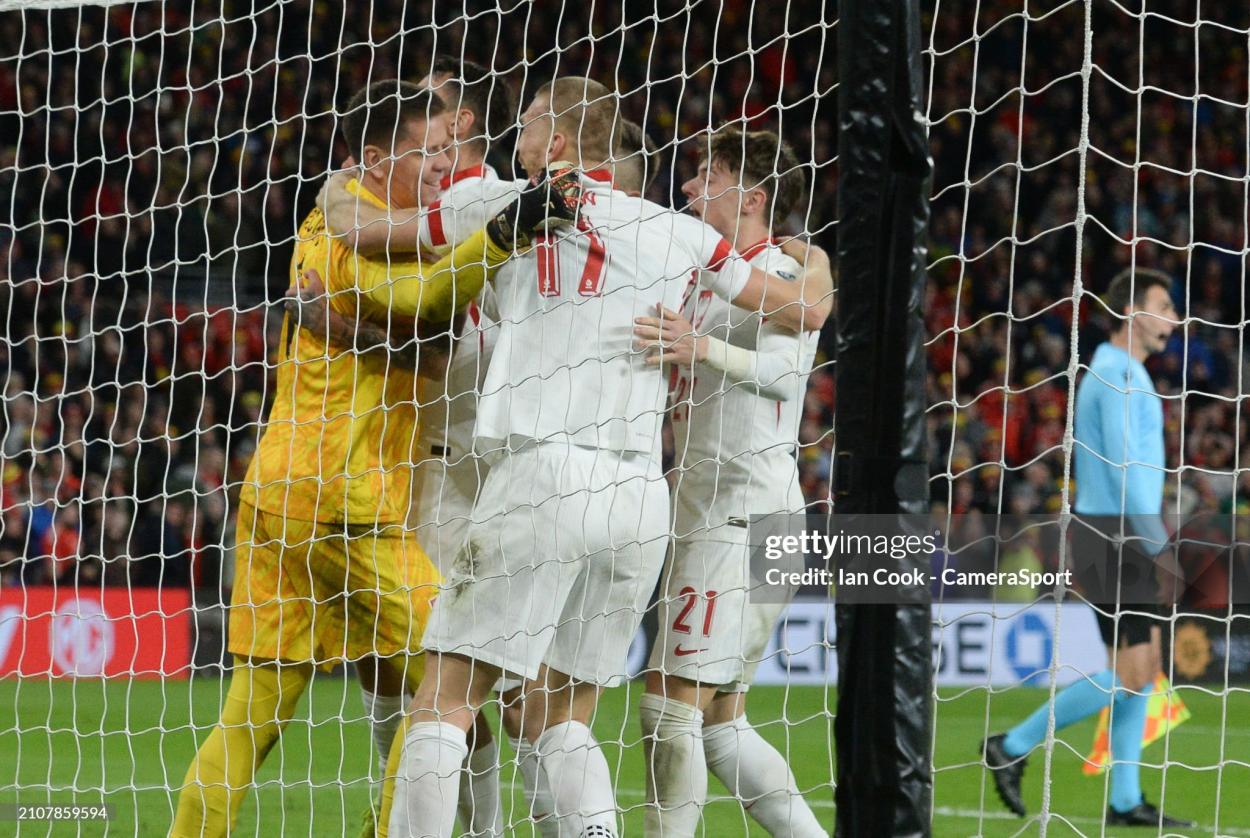 CARDIFF, WALES - MARCH 26: Poland players jump on team mate Poland's Wojciech Szczesny after winning the penalty shootout during the UEFA EURO 2024 Play-Offs Final match between Wales and Poland at Cardiff City Stadium on March 26, 2024 in Cardiff, Wales.(Photo by Ian Cook - CameraSport via Getty Images)