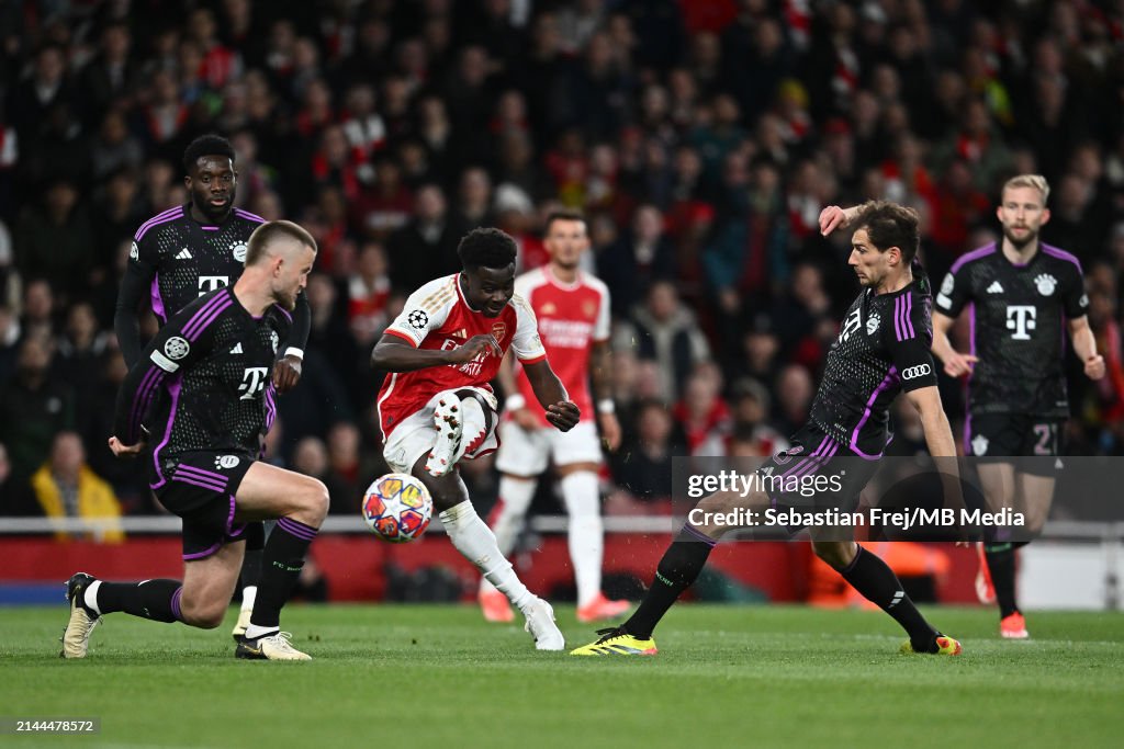 Bukayo Saka of Arsenal FC scores his team's first goal under pressure from Eric Dier and Leon Goretzka of <strong><a  data-cke-saved-href='https://www.vavel.com/en-us/soccer/2024/01/25/1169906-bayer-leverkusen-under-alonso-the-end-of-neverkusen.html' href='https://www.vavel.com/en-us/soccer/2024/01/25/1169906-bayer-leverkusen-under-alonso-the-end-of-neverkusen.html'>Bayern Munich</a></strong> during the <strong><a  data-cke-saved-href='https://www.vavel.com/en-us/soccer/2024/03/06/1175020-kylian-mbappe-brace-fires-psg-into-quarter-finals.html' href='https://www.vavel.com/en-us/soccer/2024/03/06/1175020-kylian-mbappe-brace-fires-psg-into-quarter-finals.html'>UEFA Champions League</a></strong> quarter-final first leg match between Arsenal FC and FC Bayern Munchen at Emirates Stadium on April 9, 2024 in London, England.(Photo by Sebastian Frej/MB Media/Getty Images)