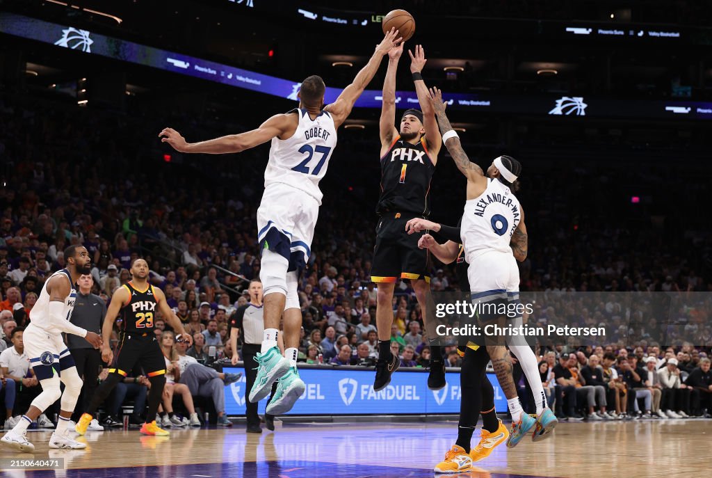 PHOENIX, ARIZONA - APRIL 28: Devin Booker #1 of the Phoenix Suns puts up a shot over Rudy Gobert #27 and Nickeil Alexander-Walker #9 of the Minnesota Timberwolves during the second half of game four of the Western Conference First Round Playoffs at Footprint Center on April 28, 2024 in Phoenix, Arizona. The Timberwolves defeated the Suns 122-116 and win the series 4-0. NOTE TO USER: User expressly acknowledges and agrees that, by downloading and or using this photograph, User is consenting to the terms and conditions of the Getty Images License Agreement. (Photo by Christian Petersen/Getty Images)