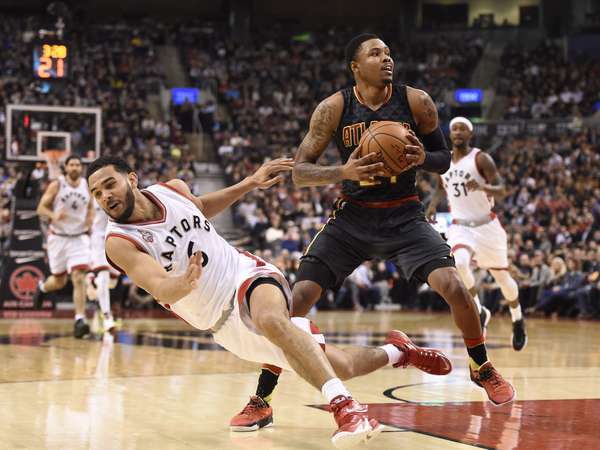 Raptors' Cory Joseph falls as Hawks' Kent Bazemore looks to make a shot. | Frank Gunn/The Canadian Press via AP