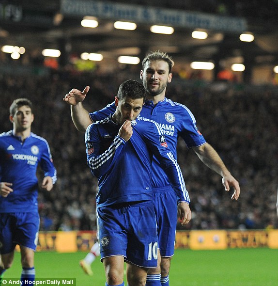 Hazard celebrates his first goal of the season by kissing the Chelsea badge