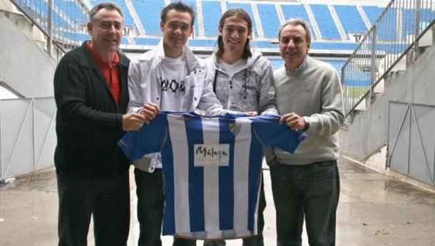 Nacho, a la izquierda, juntos a sus dos hijos, Nacho y Perico, y su hermano Juan Carlos, posando con una camiseta del Málaga
