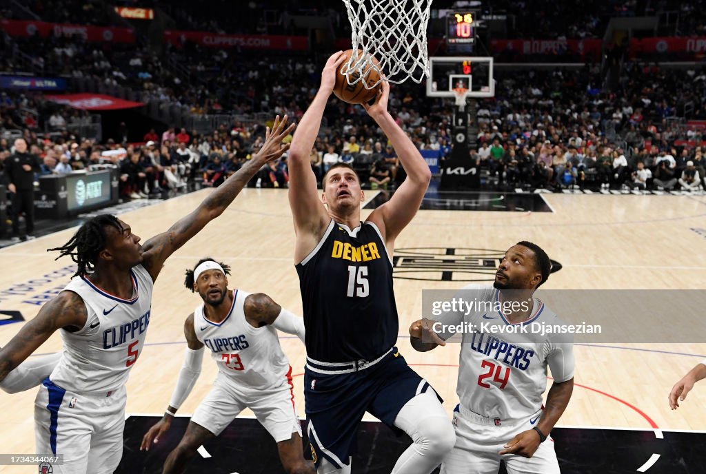 Nikola Jokic #15 of the Denver Nuggets shoots the ball against Bones Hyland #5 and Norman Powell #24 of the Los Angeles Clippers during the second half of a preseason game at Crypto.com Arena on October 19, 2023 in Los Angeles, California. (Photo by Kevork Djansezian/Getty Images)