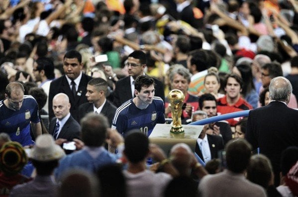 The image of Lionel Messi staring at the World Cup is one of the more iconic photos in sports history (Bao Tailiang, Chengdu Economic Daily)