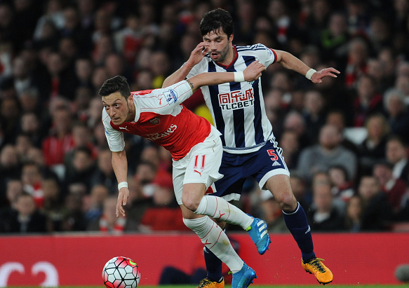 Ozil tussling with Claudio Yacob (behind) in possession for the ball. | Photo: Getty