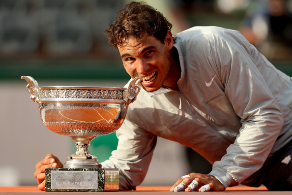 Nadal posing with his most recent Grand Slam singles title at the French Open in 2014 (Photo by Matthew Stockman / Getty Images)