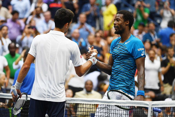 Djokovic and Monfils shake hands at the net (Photo by Alex Goodlett/Getty Images)
