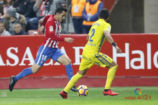 Isma López conduce un balón ante un jugador del Cádiz en El Molinón | Imagen: LaLiga
