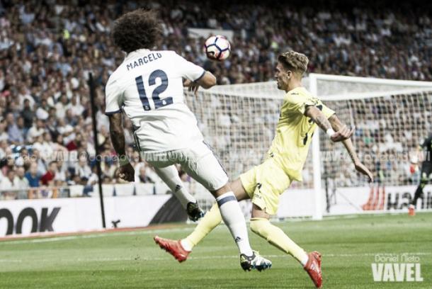 Marcelo cuelga el balón al área ante la presión de un rival | Foto: VAVEL