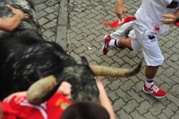 Un mozo es arrollado por uno de los toros, que casi roza al fotógrafo. / Foto: Alberto Galdona