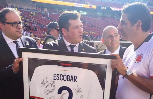 El presidente de CONMEBOL Alejandro Domínguez le entrega la camiseta conmemorativa de la Selección Colombia al hermano de Andrés Escobar, Santiago. | Foto: CONMEBOL