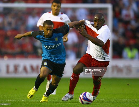 WALSALL, UNITED KINGDOM - JULY 22: Wayne Routledge of Aston Villa battles for the ball with Patrick Suffo of Walsall during the Pre Season Friendly match between Walsall and Aston Villa at the Bescot Stadium on July 22, 2008 in Walsall, England. (Photo by Paul Gilham/Getty Images)