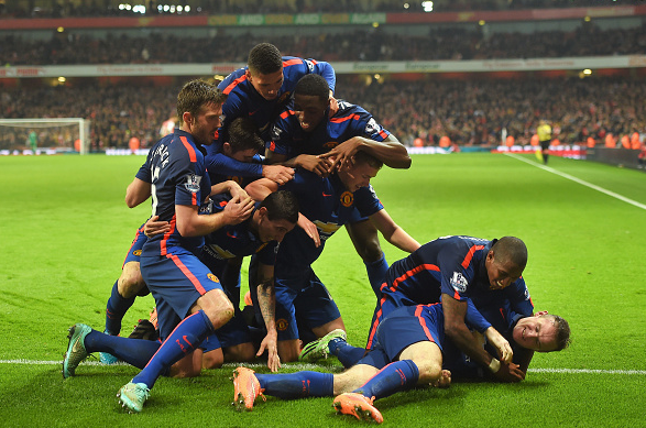 Rooney celebrates his winner alongside his teammates at the Emirates | Photo: Getty