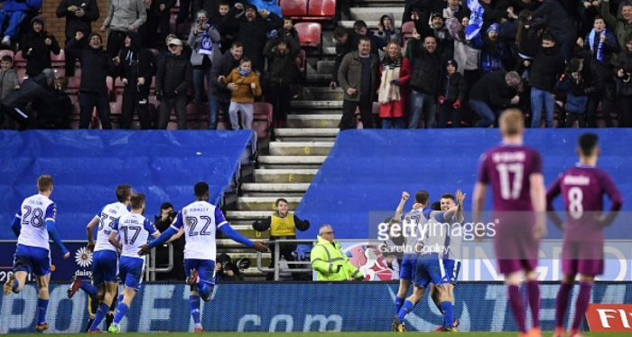 WIGAN, ENGLAND - FEBRUARY 19: William Grigg of Wigan Athletic celebrates with teammates after scoring his sides first goal during the Emirates FA Cup Fifth Round match between Wigan Athletic and Manchester City at DW Stadium on February 19, 2018 in Wigan,